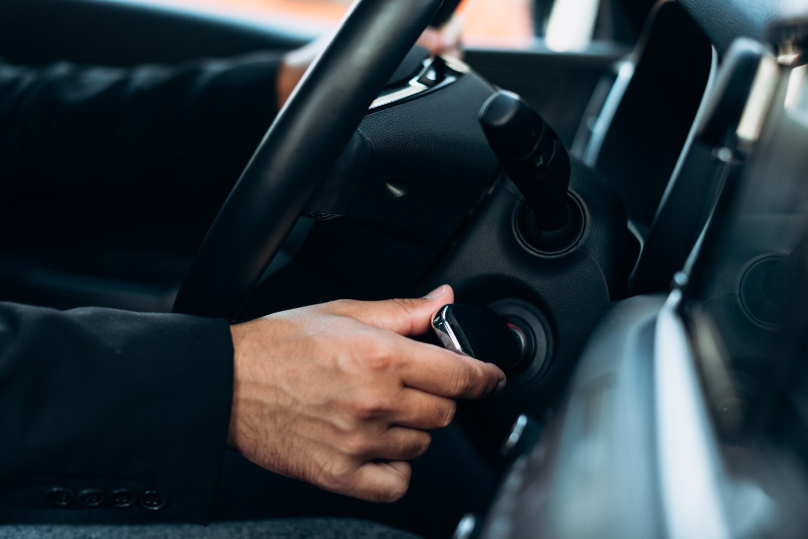 Closeup shot of man inserting key in car ignition lock